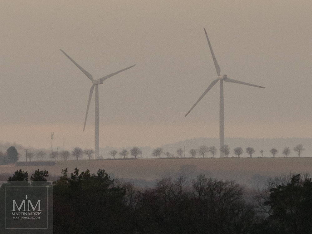 Dvě větrné elektrárny v krajině. Fotografie vytvořená objektivem Olympus M. Zuiko digital ED 40 - 150 mm 1:2.8 PRO.